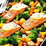 Lemon Butter Salmon with Roasted Broccoli and Potatoes, beautifully plated with salmon fillets, roasted potatoes, and vibrant green broccoli, garnished with lemon slices and fresh herbs.